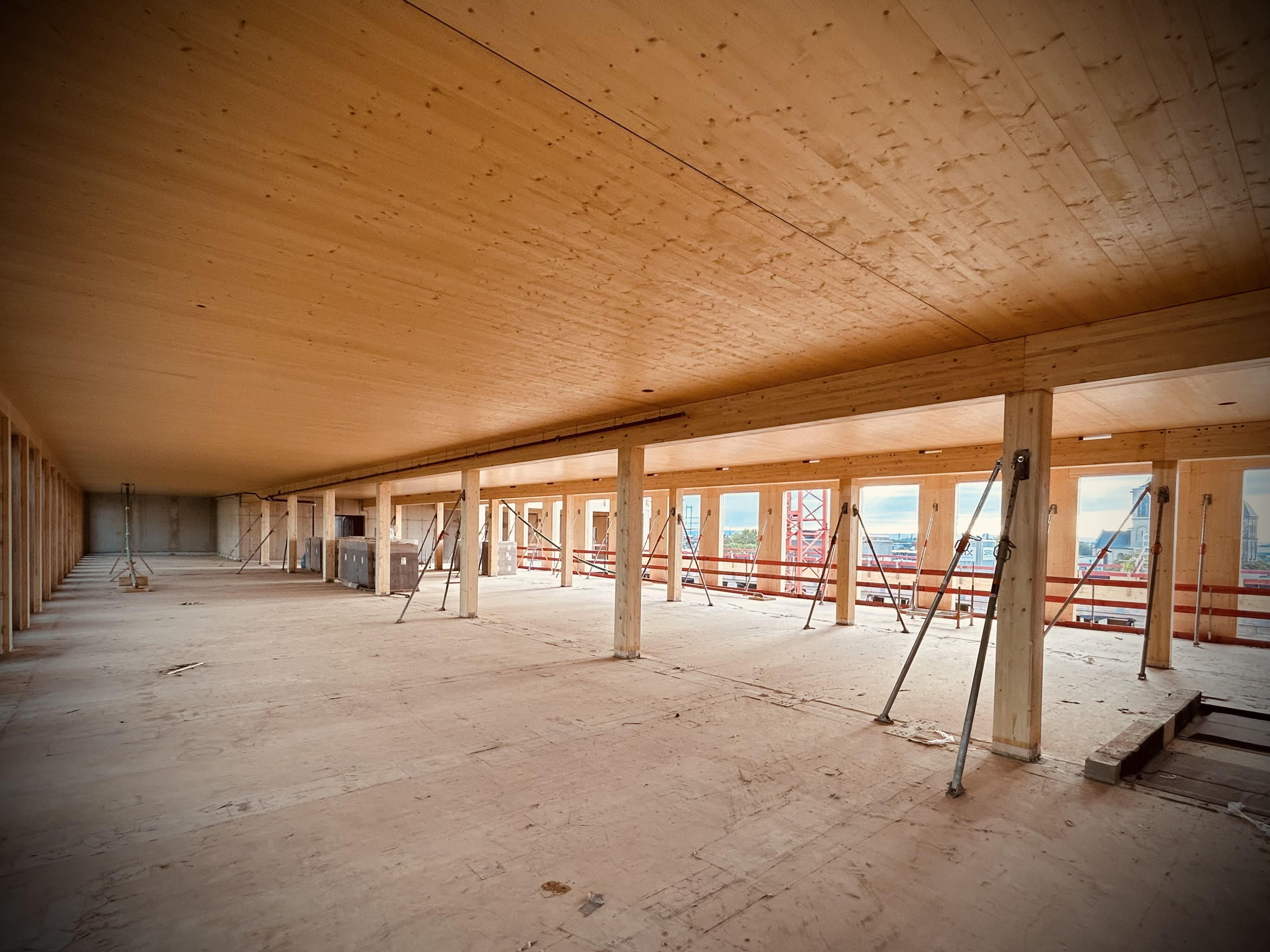 Innenraum des MACO-Bauvorhabens mit massiven Holzdecken und Stützen auf der Baustelle